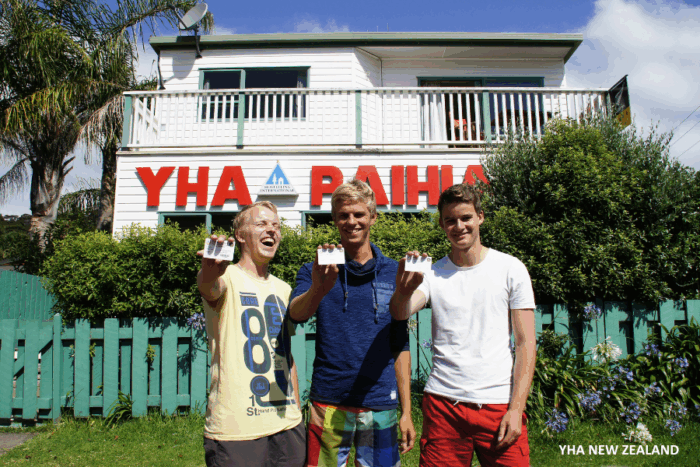 Nuoria seisomassa hostellikortti kädessä hostellin edessä