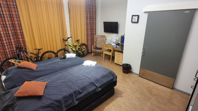 Hostellihuone, jossa kaksi sänkyä. Reissaajien fillarit mahtuvat myös tilavaan huoneeseen.