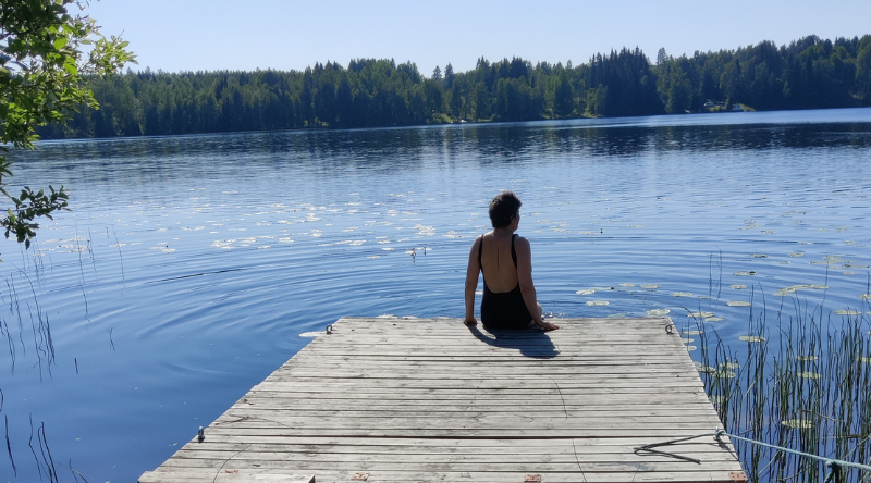 Nainen istuu laiturilla