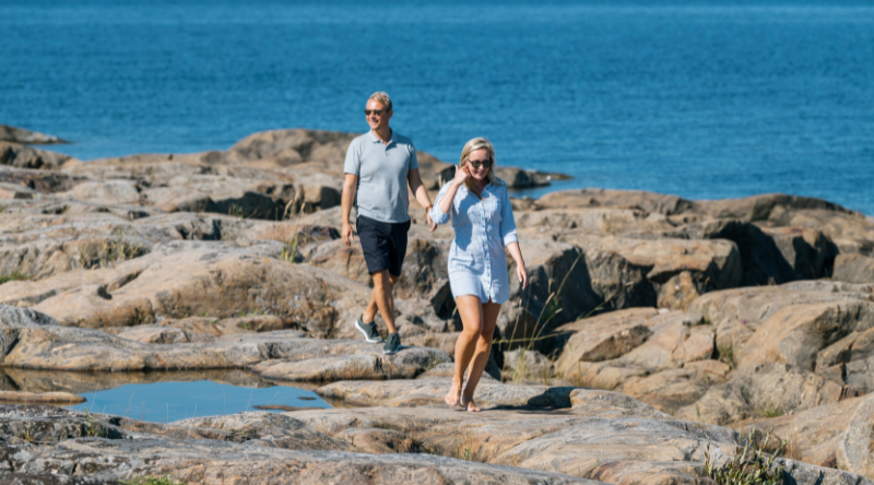 Pariskunta kävelee Tankarin kallioilla