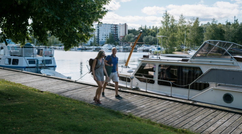 Pariskunta kävelee järven rantaa
